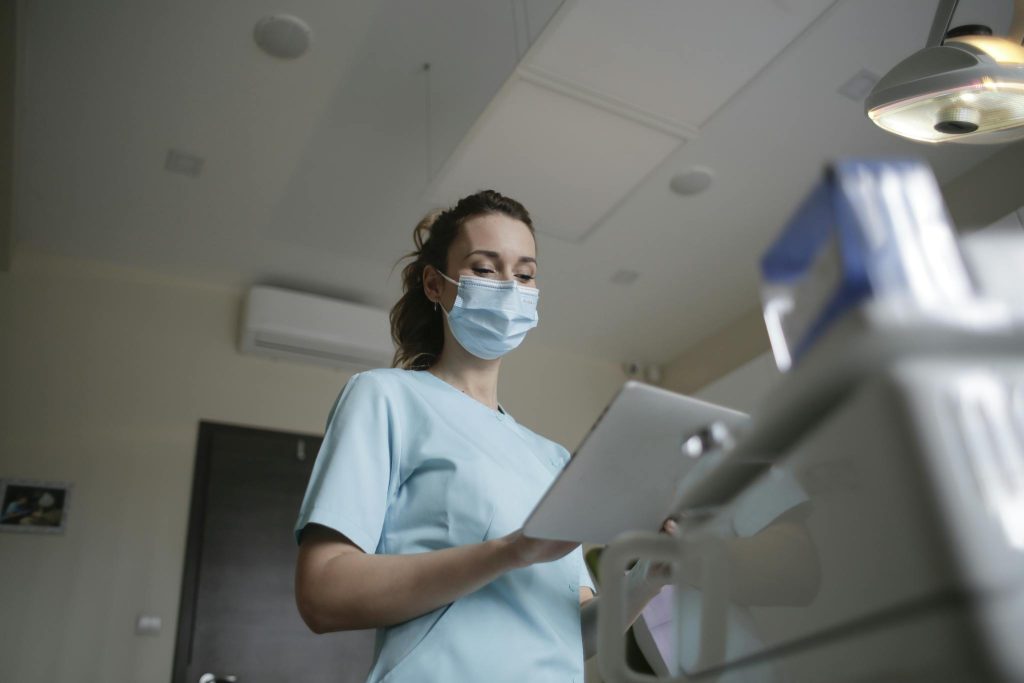 Photo Of nurse Wearing A Surgical Mask researching healthcare education management systems