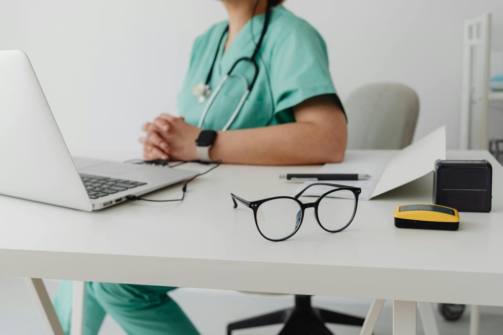 Nurse or physician in Blue Scrub Suit Using Macbook Pro to do research