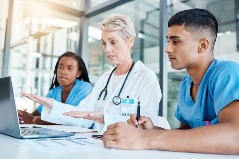 Doctor with nurses reviewing research article