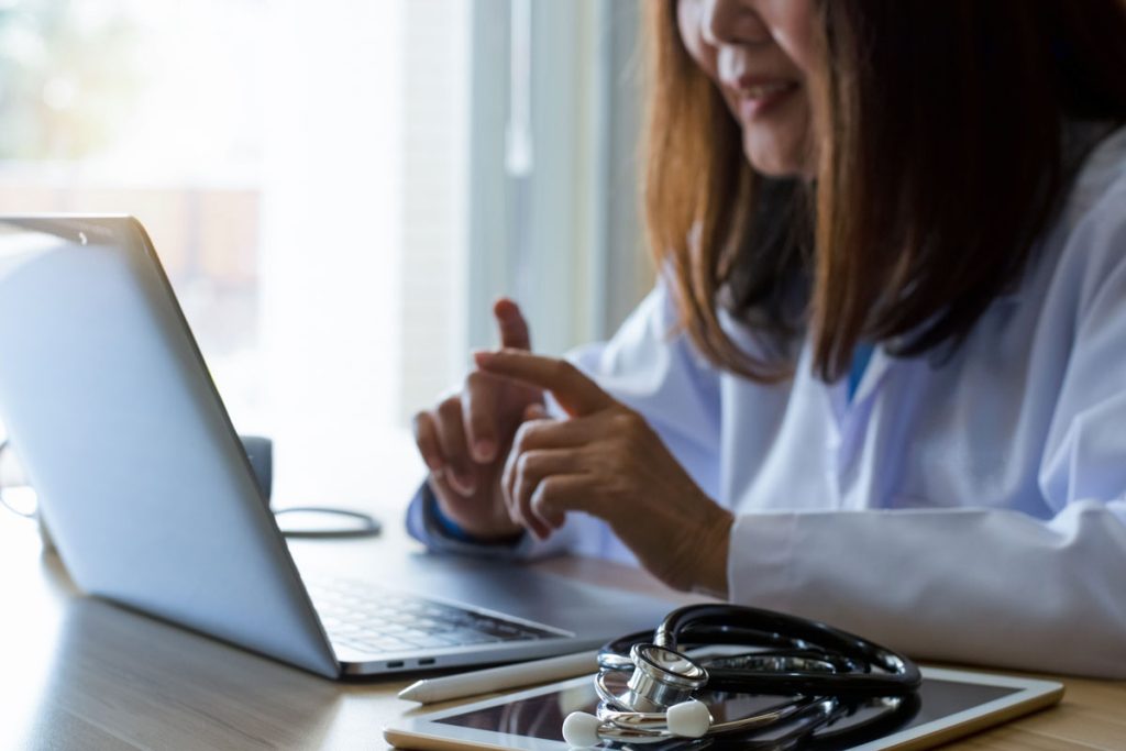 Dr reading medical journal on laptop